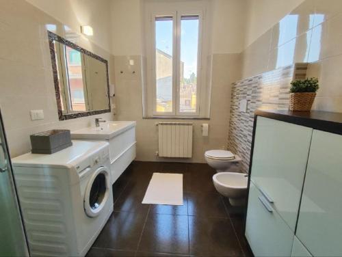 a bathroom with a washing machine and a toilet at B&B Intero Appartamento Forum e Metro Milanofiori in Assago