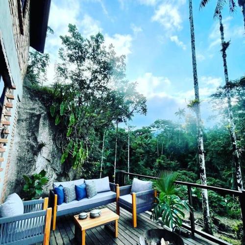 a patio with a couch and a table on a balcony at Casa da Pedra Serrinha in Resende