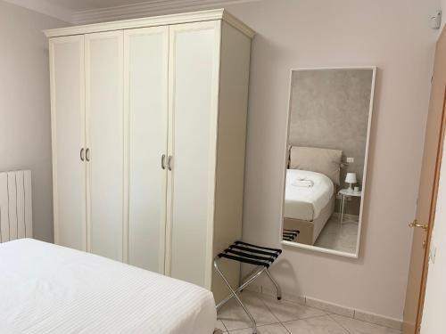 a bedroom with a white cabinet and a mirror at La Casetta in Folignano