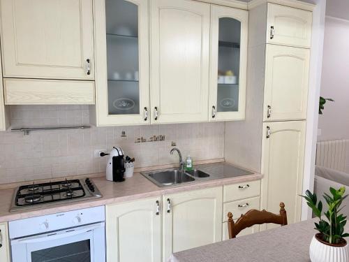 Folignano的住宿－La Casetta，厨房配有白色橱柜和水槽