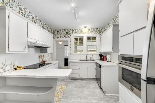 a white kitchen with white cabinets and appliances at Noi Nest Home + Pool + Suites in Melbourne