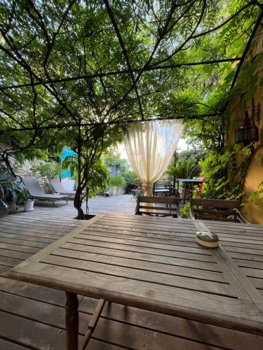 una mesa de picnic de madera en una terraza con un árbol en L'Oasis, en Marsella