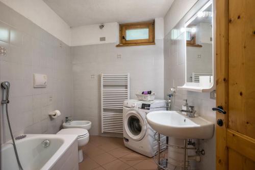 bagno con lavatrice e lavandino di Casa Peio a Peio