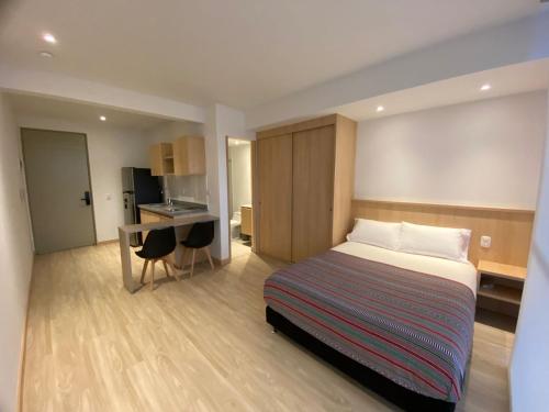 Habitación de hotel con cama y escritorio en Estar Apartahotel, en Manizales