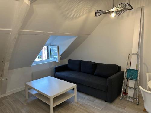 un salon avec un canapé et une table dans l'établissement appartement centre ville LILLEBONNE 2eme etage, à Lillebonne