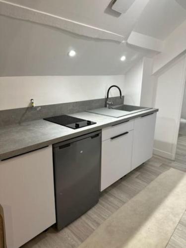 een witte keuken met een wastafel en een fornuis bij appartement centre ville LILLEBONNE 2eme etage in Lillebonne