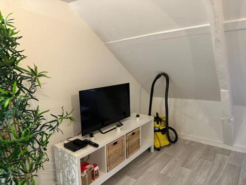 een woonkamer met een flatscreen-tv op een plank bij appartement centre ville LILLEBONNE 2eme etage in Lillebonne