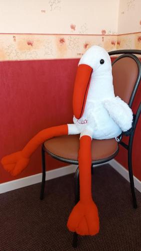 a stuffed bird is sitting on a chair at Hôtel Le Pommeil in Guéret