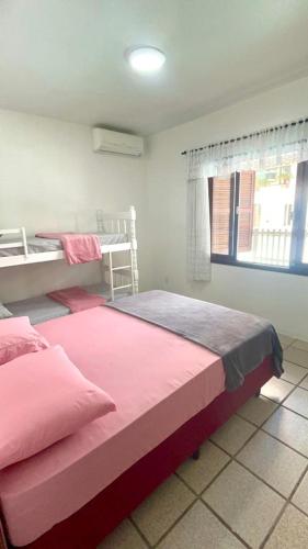 sypialnia z 2 łóżkami piętrowymi i oknem w obiekcie Casa na praia de Bombas com Piscina w mieście Bombinhas