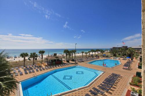 a view of a pool with chairs and the beach at The Summit by Panhandle Getaways in Panama City Beach