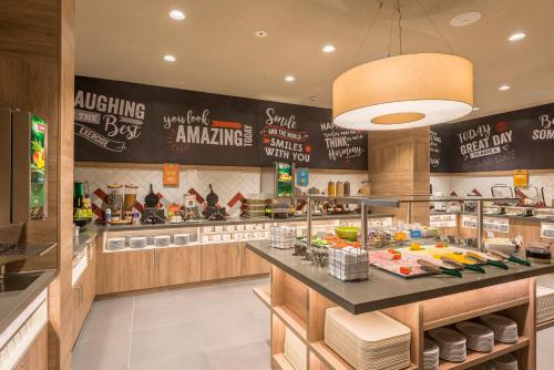 a fast food restaurant with a counter with food at Hampton By Hilton Frankfurt City Centre East in Frankfurt