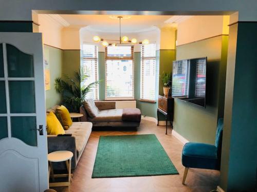 a living room with a couch and a tv at Cheerful 4 bedroom townhouse, side street parking in Belfast