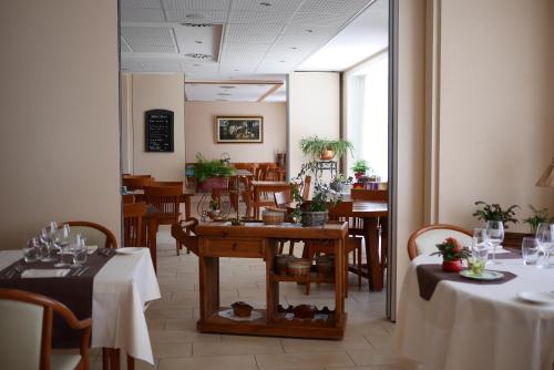 ein Esszimmer mit Tischen und Stühlen in einem Restaurant in der Unterkunft Auberge Aux Deux Sapins in Montricher