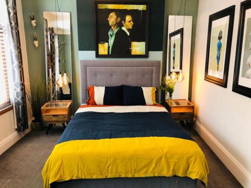 a bedroom with a bed with a yellow and blue blanket at Cheerful 4 bedroom townhouse, side street parking in Belfast