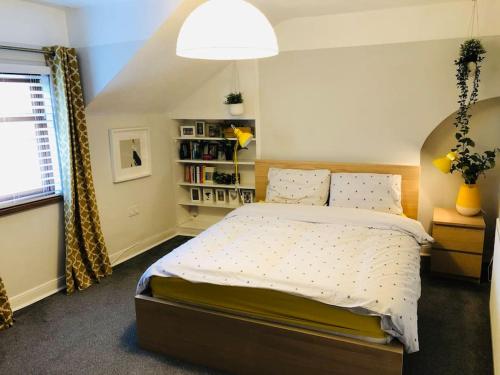 een slaapkamer met een groot bed en een raam bij Cheerful 4 bedroom townhouse, side street parking in Belfast