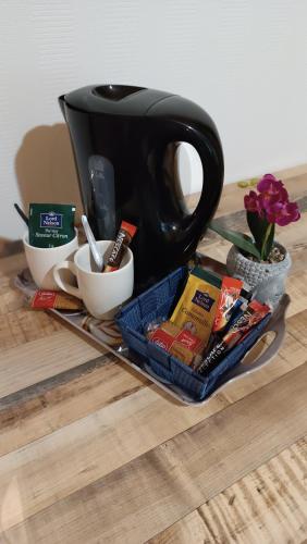 a tray with a tea pot and other items on a table at Hôtel Le Pommeil in Guéret