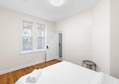 ein weißes Schlafzimmer mit einem Bett und einem Fenster in der Unterkunft Newly Renovated Guest Rooms near Transportation in Philadelphia