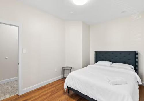 a white bedroom with a bed and a mirror at Newly Renovated Guest Rooms near Transportation in Philadelphia