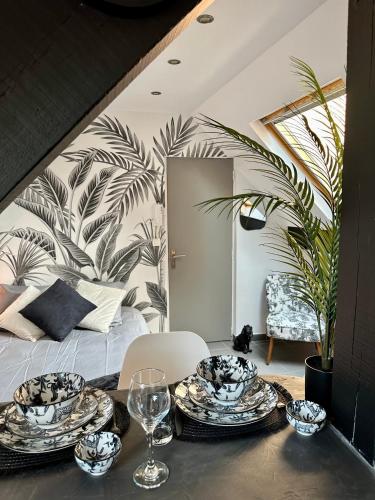 une salle à manger avec une table, des assiettes et des verres dans l'établissement Studio chaleureux hypercentre Amiens, à Amiens