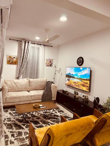 sala de estar con sofá y TV en Cozy Up and Relax at Oysterbay, en Dar es Salaam