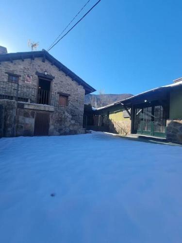 a stone building with a blue sky in the background at Casa Rural Maria de Isidro in Caboalles de Arriba