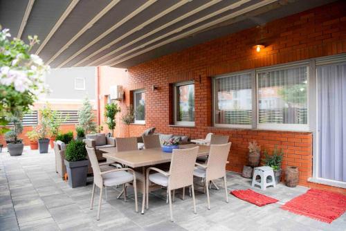 a patio with a table and chairs and a brick wall at Unique Apartments in Prishtinë