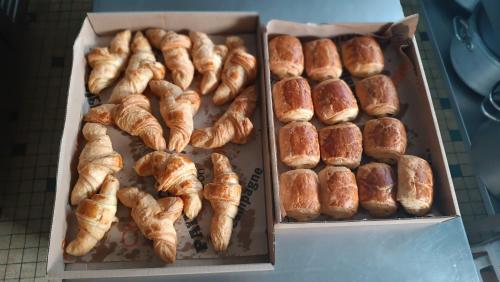 two boxes filled with croissants and other pastries at Hôtel Le Pommeil in Guéret