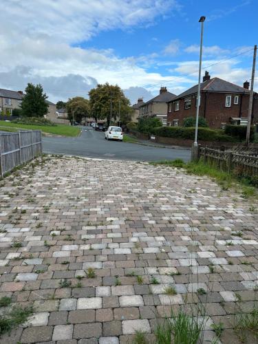 a car driving down a street with a brick road at Cheerful 3 bed semi-detached property in Bradford