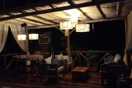 a patio with chairs and a table and lights at Casa da Pedra Serrinha in Resende