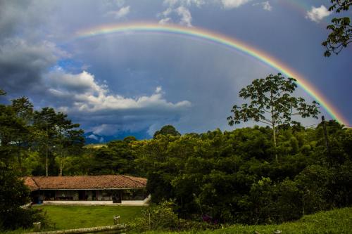 a rainbow in the sky over a house at Villa Cristina - Casa Boutique in Pereira
