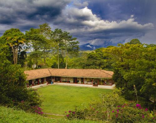 a house with a large yard in a field at Villa Cristina - Casa Boutique in Pereira