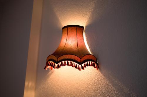 a lamp hanging on a wall in a room at Archontiko Alexandros Luxury Suites in Kardiá