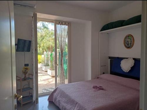 1 dormitorio con 1 cama y puerta corredera de cristal en Casa Sonia en Ischia