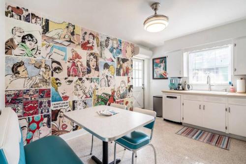 a kitchen with a table and a wall covered in pictures at In the Center of Gulfport, Min Away From the Beach! in St. Petersburg