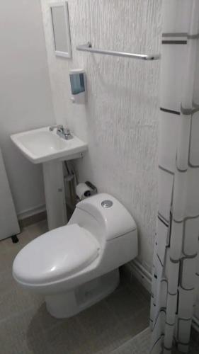 a bathroom with a white toilet and a sink at Q'entiHospedaje San Blas 1 in Cusco