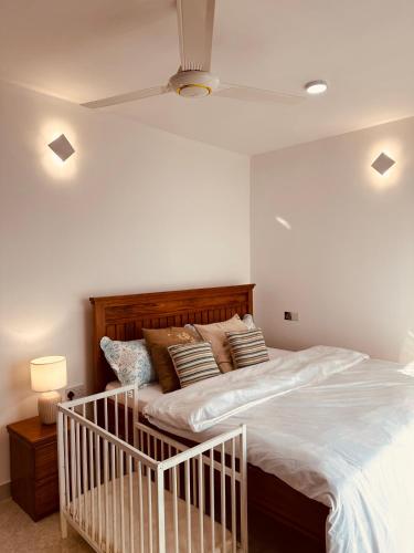 een slaapkamer met een groot bed met witte lakens en kussens bij Cozy Up and Relax at Oysterbay in Dar es Salaam