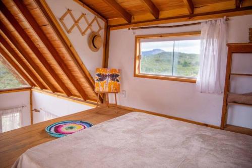 um quarto com uma cama num quarto com uma janela em Chalé Vida Boa: Paz e Aconchego em Vale do Capao