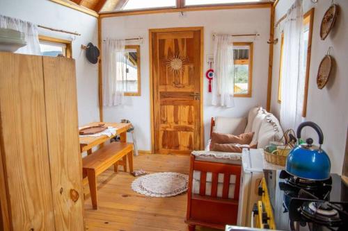 um quarto com uma cozinha com uma mesa e uma porta em Chalé Vida Boa: Paz e Aconchego em Vale do Capao