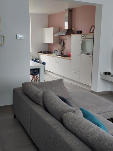 ein Wohnzimmer mit einem Sofa und einer Küche in der Unterkunft Kleine Dijk in Diksmuide