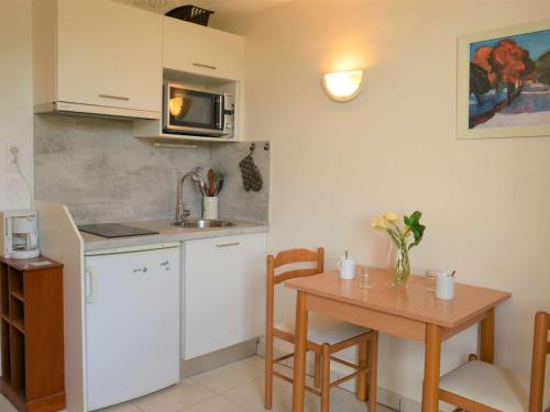 une petite cuisine avec une table et un micro-ondes dans l'établissement Appartement 2 pièces en bord de mer, 3 couchages - Argelès-sur-Mer - FR-1-225-26, à Argelès-sur-Mer