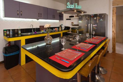 a kitchen with a long table with red napkins at Twakila Sunset Suites in La Gaulette