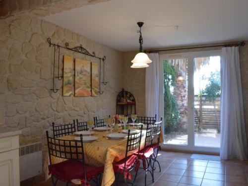 une salle à manger avec une table et un mur en pierre dans l'établissement Maison 4 pièces, terrasse, proche plage, 6 pers., Narbonne Plage - FR-1-229B-131, à Narbonne
