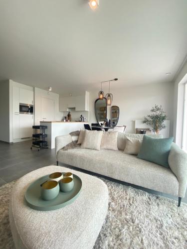 un soggiorno con divano e tavolo di Luxe 4p appartement aan jachthaven van Zeebrugge Met terrassen en gratis parkeren a Zeebrugge