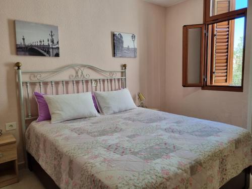 プラヤ・デ・ラス・アメリカスにあるVirginiaのベッドルーム1室(紫と白の枕が備わる大型ベッド1台付)