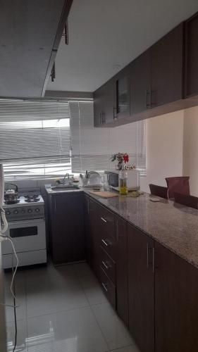 a kitchen with a sink and a stove in it at DEPARTAMENTOS AMOBLADOS EN JOSE LUIS BUSTAMANTE Y RIVERO AREQUIPA -PERU in Arequipa