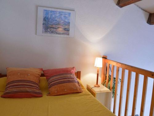 a bedroom with a yellow bed with two pillows at Maison Fleury-Saint-Pierre-la-Mer, 3 pièces, 6 personnes - FR-1-229D-227 in Saint Pierre La Mer