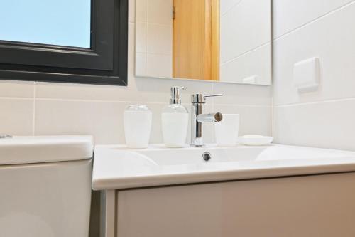 a bathroom with a white sink and a mirror at Casa Familia Pestana 1, a Home in Madeira in Seixal