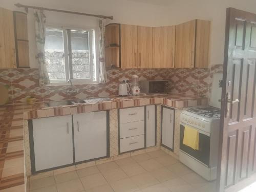 een keuken met witte kasten en een fornuis met oven bij Vipingo royal homes in Kilifi