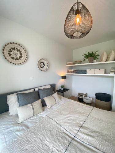 a bedroom with a large white bed with pillows at Luxe 4p appartement aan jachthaven van Zeebrugge Met terrassen en gratis parkeren in Zeebrugge