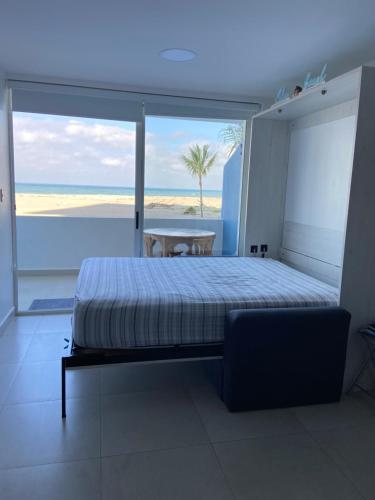 een slaapkamer met een bed en uitzicht op het strand bij Ocean Club - Ocean Suites II in Playas